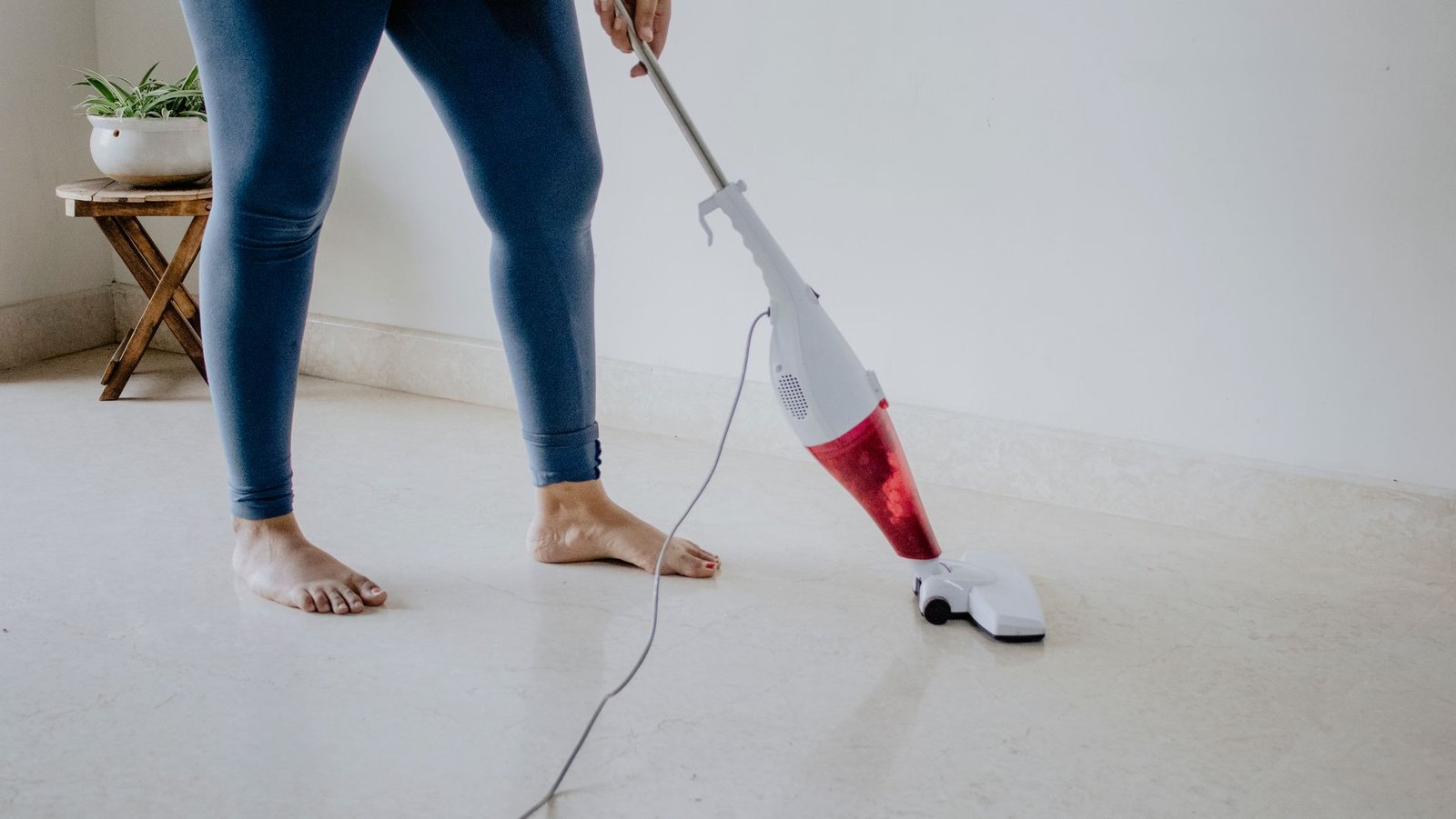 Close-up of a woman vacuuming a clean marble floor barefoot, show