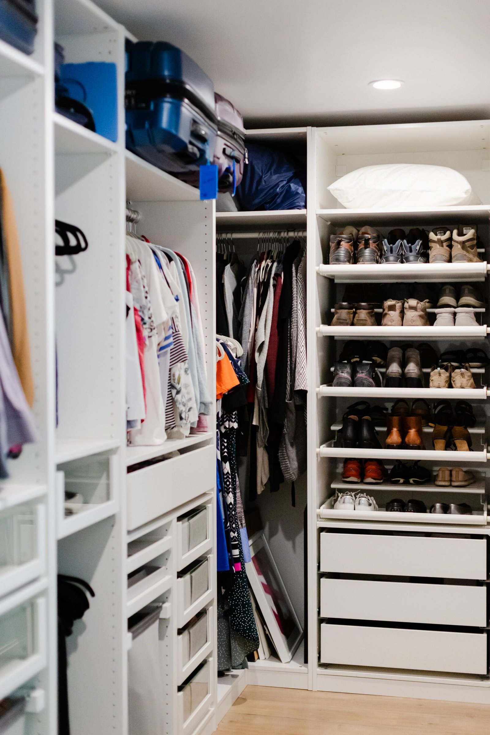 A well-organized walk-in closet featuring clothes and shoes neatl