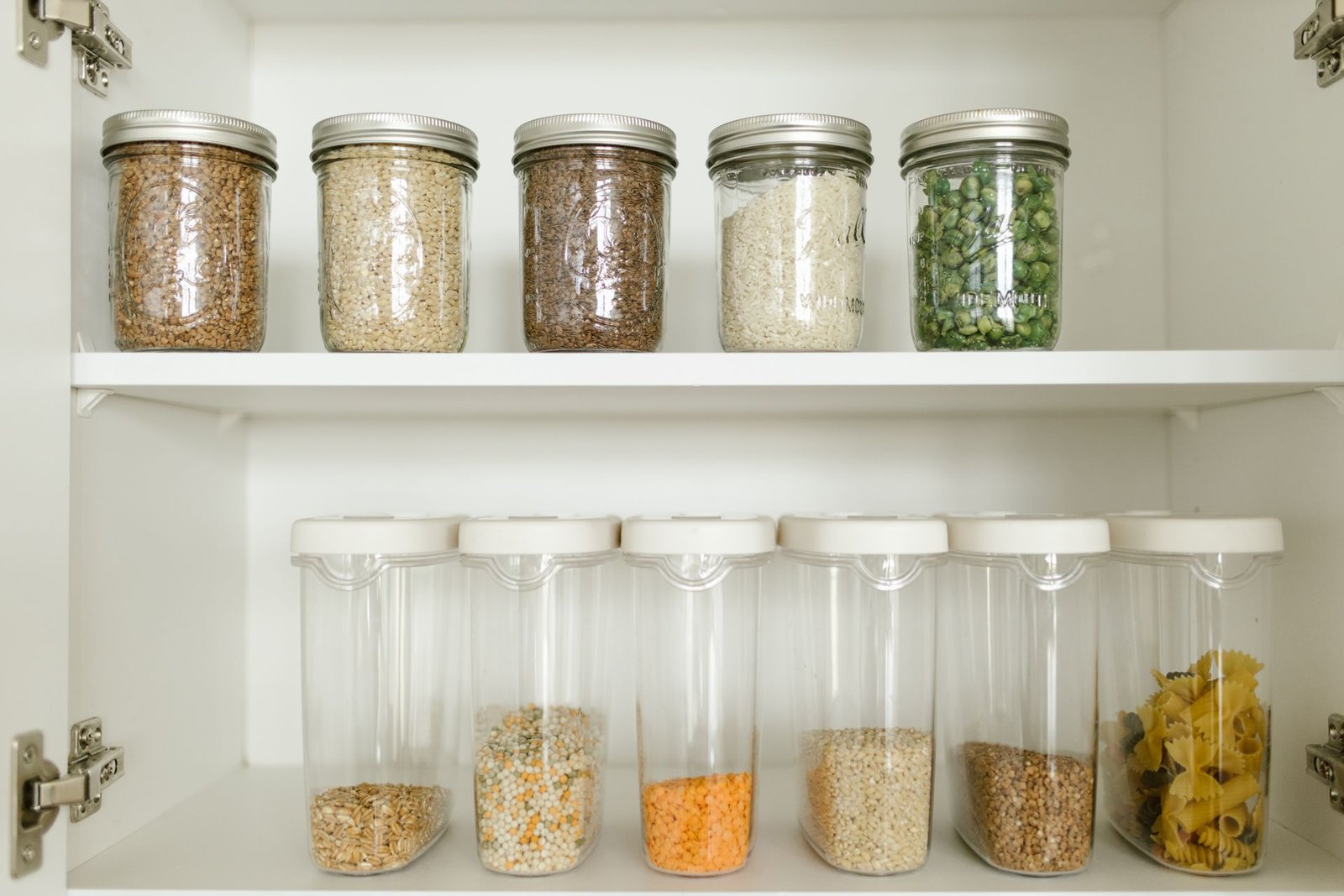Neatly arranged pantry showcasing grains in glass jars and dry go