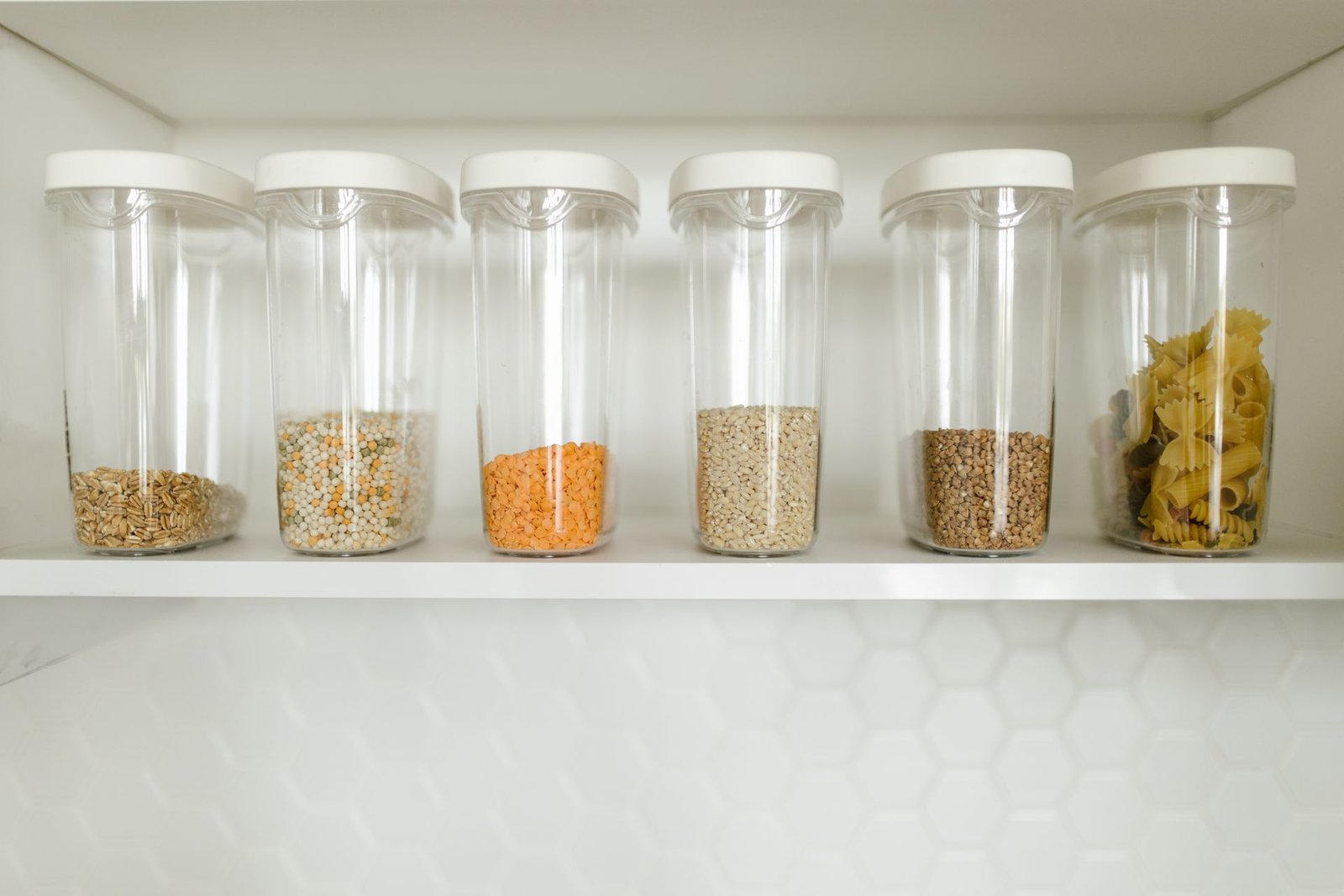 Clear containers filled with grains, pasta, and seeds, neatly org