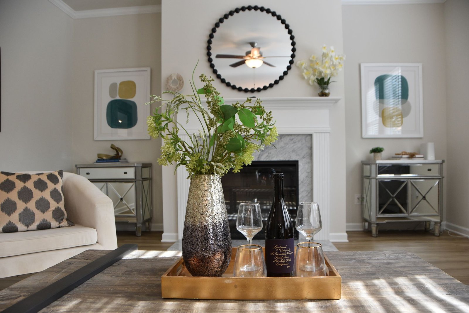 A modern living room featuring a decorative mirror, vase with flo