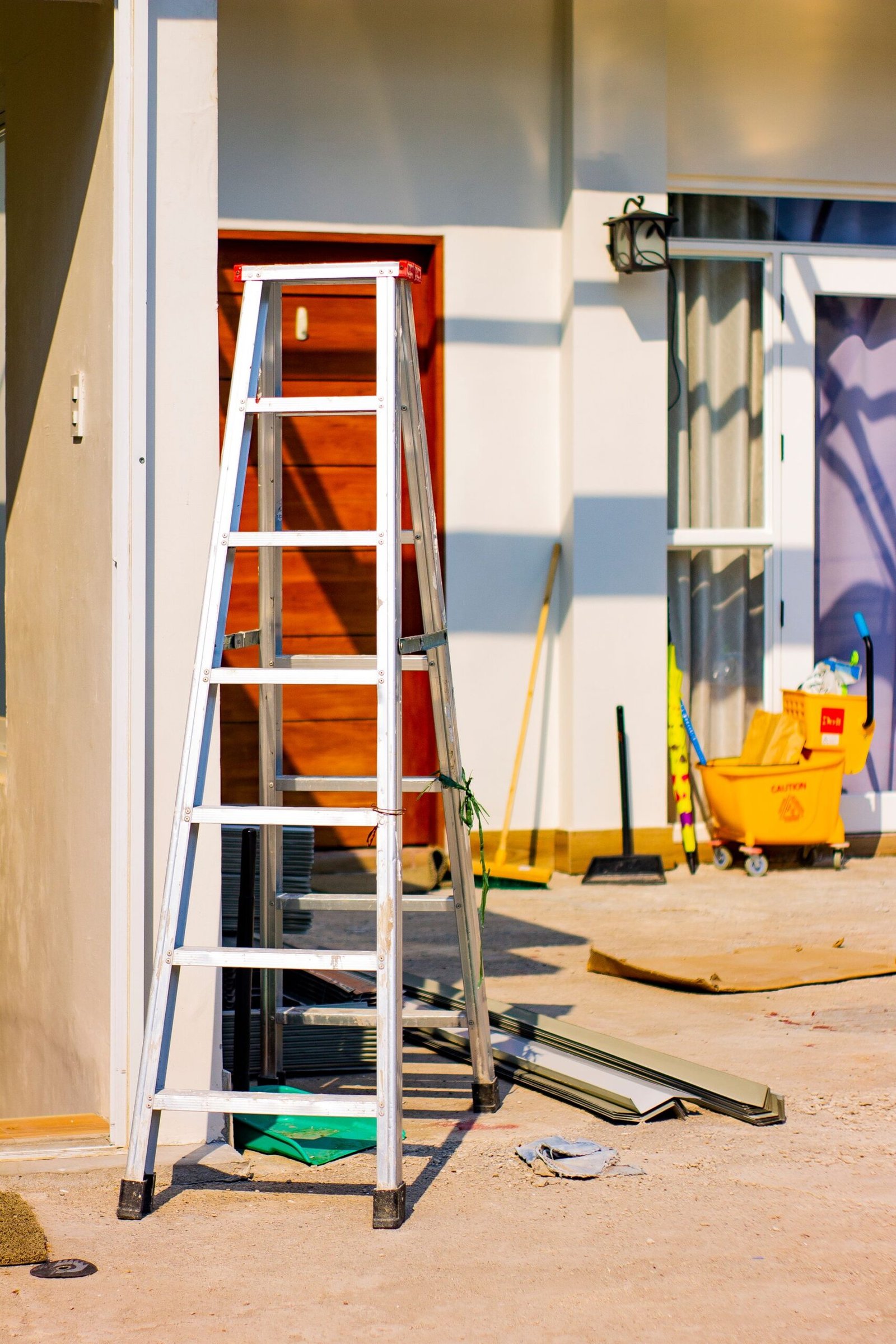 An outdoor home renovation scene featuring a ladder and various t
